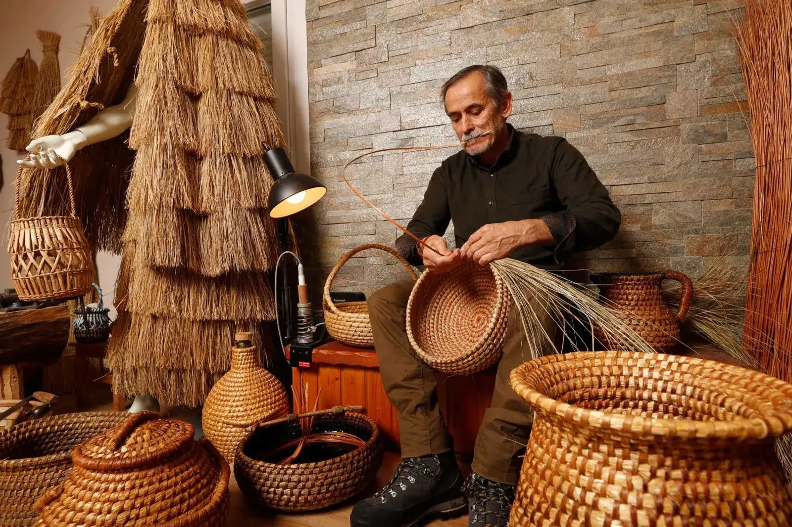 Artesano cestero trabajando una pieza de fibra natural en su taller