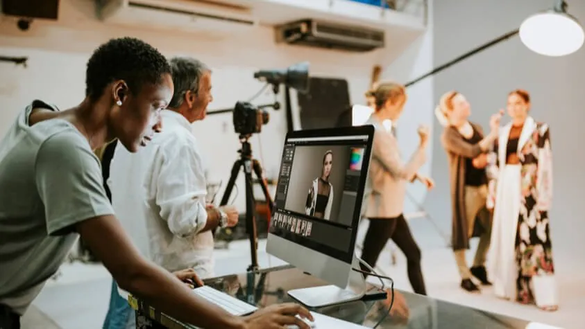 Director de arte revisando en pantalla una sesión de fotos de moda en estudio