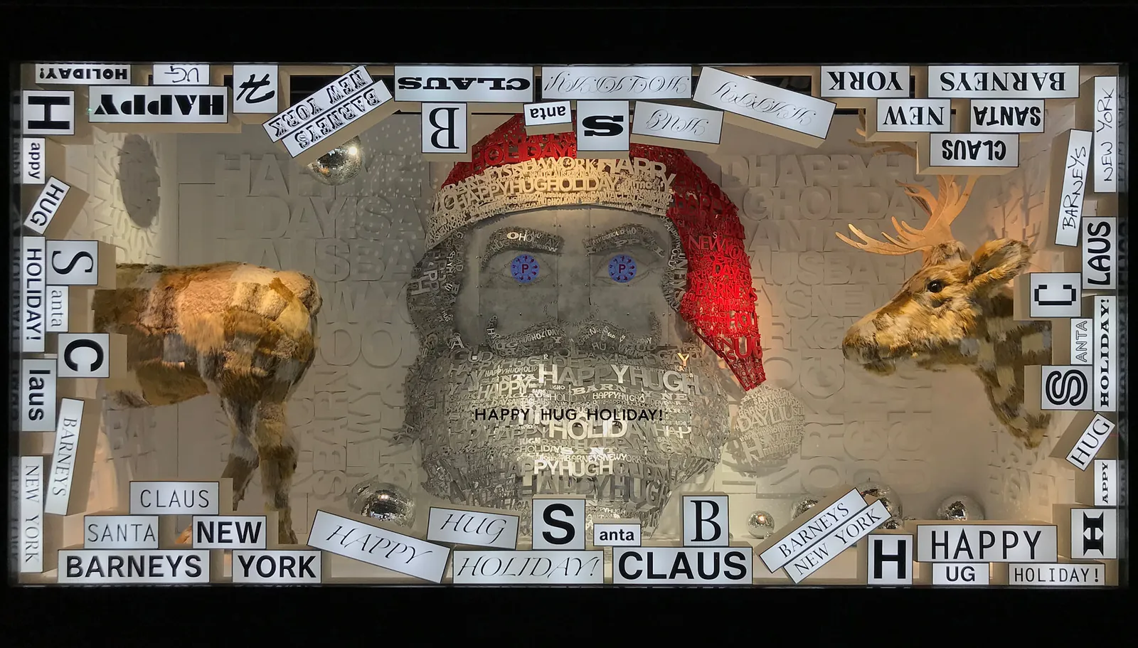 Escaparate de Navidad con un Papá Noel hecho de letras, cabezas de ciervo doradas y un marco de carteles tipográficos