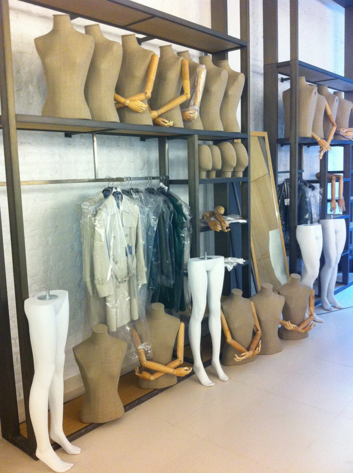 Bustos de maniquí y prendas preparadas para un montaje en la trastienda de una tienda de moda